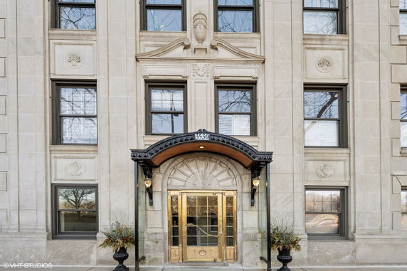 Front view of a multi-story building with decorative stone design and an ornate entrance.