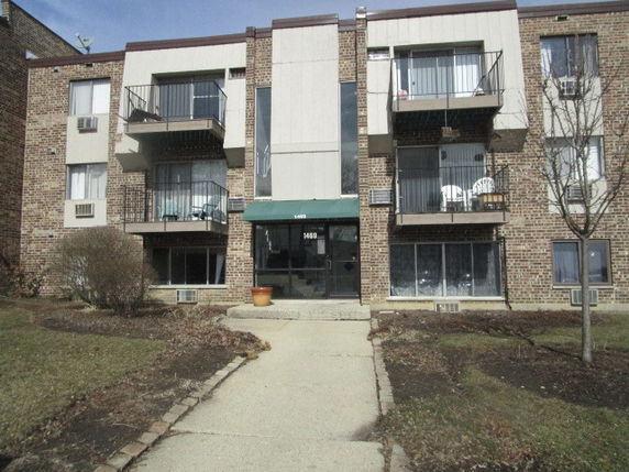 Front view of a three-story apartment building with balconies.
