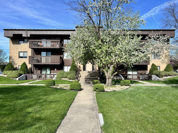 Front view of a multi-story residential building with balconies.