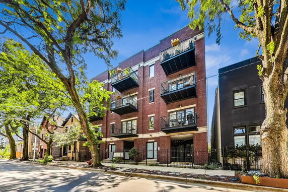 Front view of a multi-story brick building with balconies.