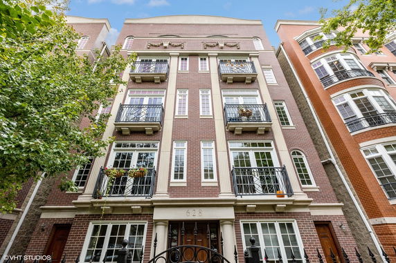 Front view of a multi-story brick building with balconies and large windows.