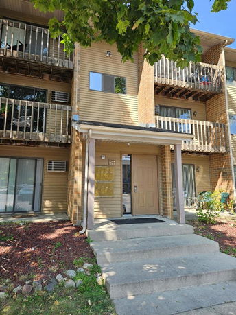 Front view of a multi-story apartment building with balconies and a main entrance.