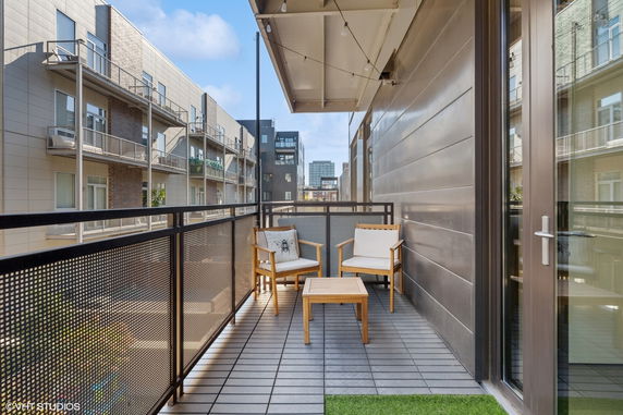 Balcony view overlooking modern apartment buildings and cityscape.