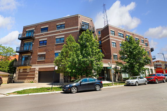 Front view of a multi-story brick building with balconies.