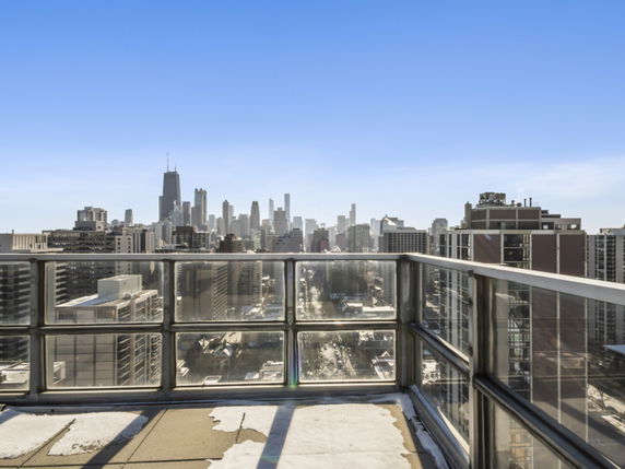 Wide angle view of cityscape from a rooftop balcony.