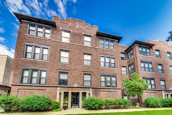 Front view of a multi-story brick apartment building.