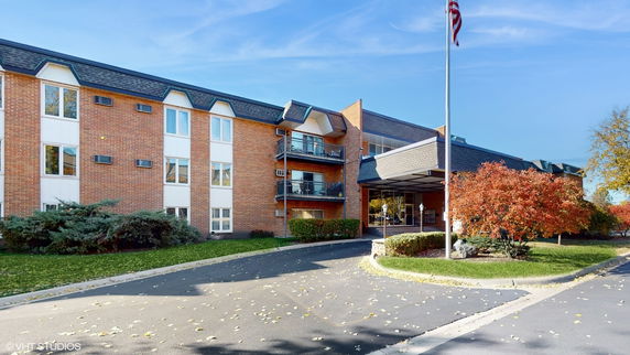 Front view of a multi-story brick building with a covered entrance.