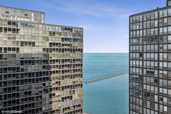 Panoramic view between two high-rise buildings overlooking a large body of water.