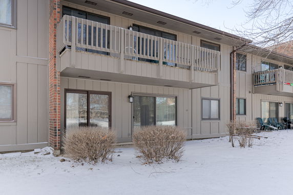 Front view of a two-story building with balconies and sliding glass doors.