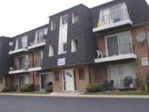 Front view of a three-story apartment building with balconies.