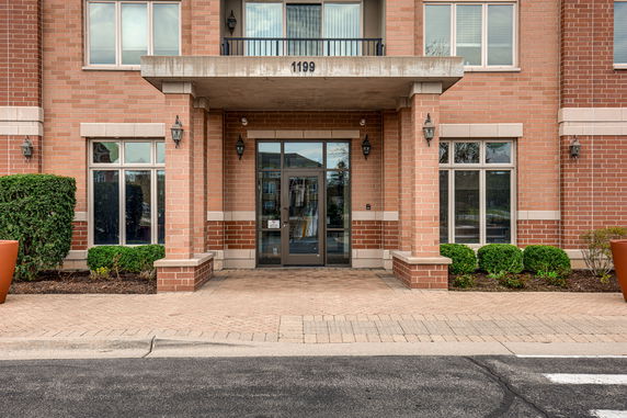 Front view of a brick building entrance with large glass doors and windows.