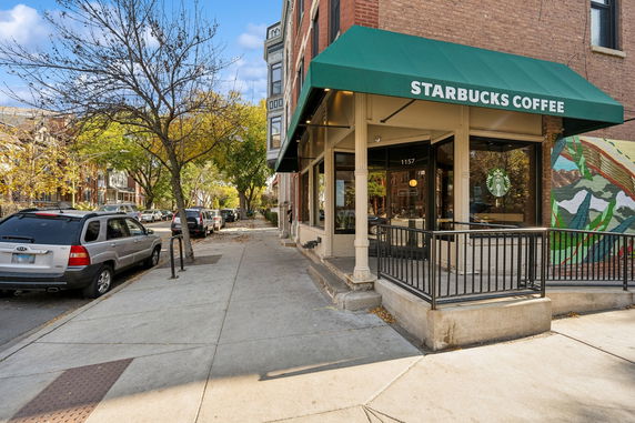 Front view of a Starbucks coffee shop with a green awning.