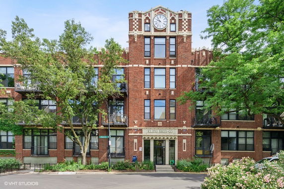 Front view of a multi-story brick building with a clock tower.