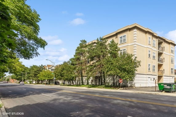 Front view of a multi-story apartment building with trees nearby.