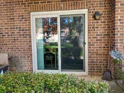 Front view of a building with a sliding glass door and a brick exterior.