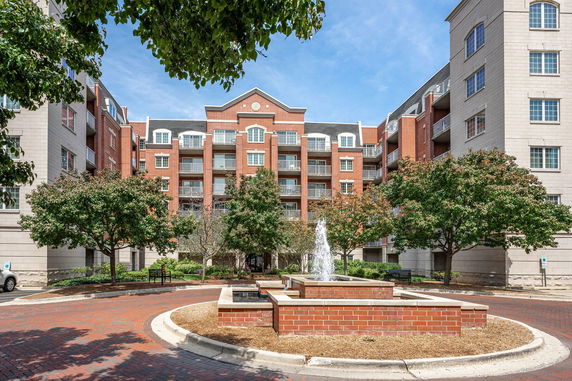 Front view of a multi-story brick apartment building with balconies.