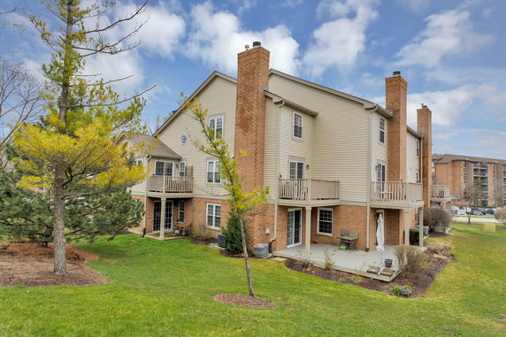 Side view of a multi-story residential building with multiple balconies and chimneys.