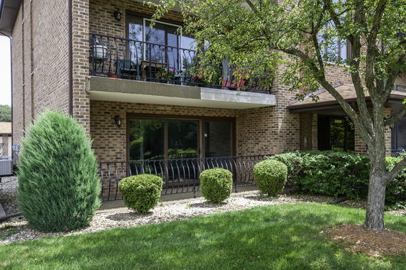 Front view of a brick apartment building with balconies.