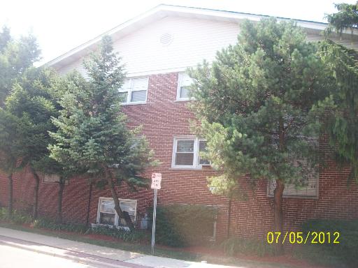 Front view of a two-story brick building with trees in front.