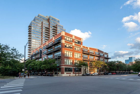 Front view of a multi-story building with brick facade and balconies.