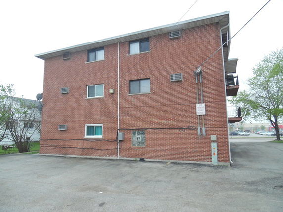 Side view of a three-story brick apartment building.
