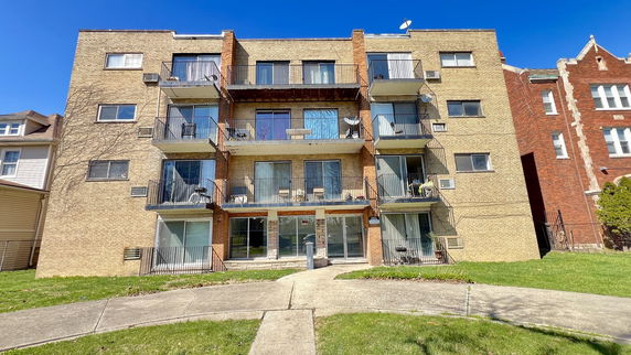 Front view of a multi-story apartment building with balconies.