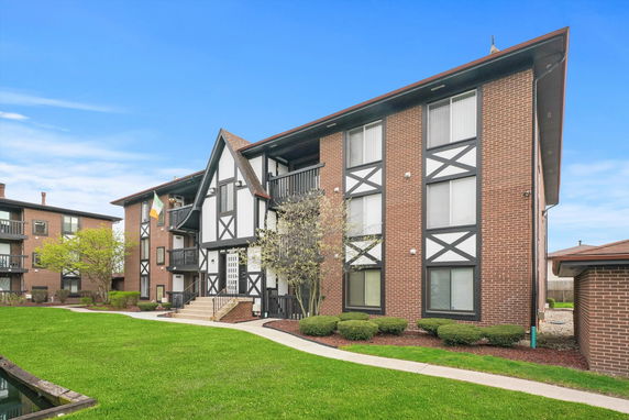 Front view of a multi-story residential building with brick and patterned facade.
