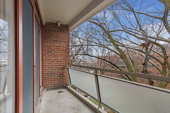 View from a balcony overlooking trees and buildings.