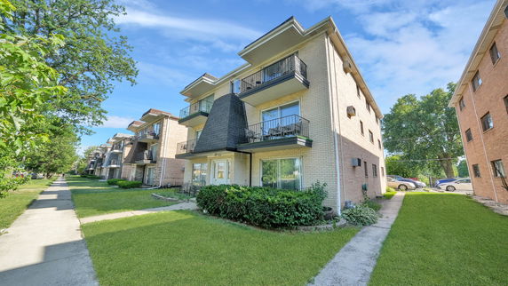 Front view of a multi-story apartment building with balconies.