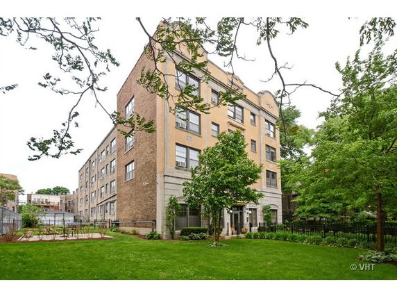 Front view of a multi-story apartment building with brick exterior.