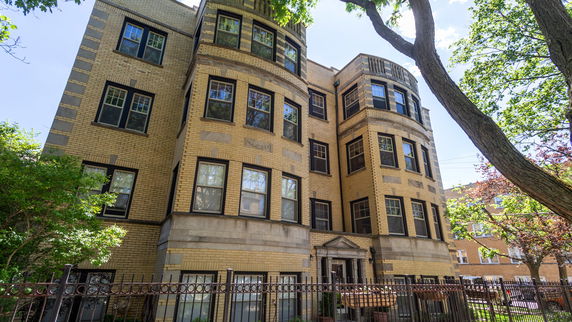 Front view of a multi-story brick building with multiple windows.