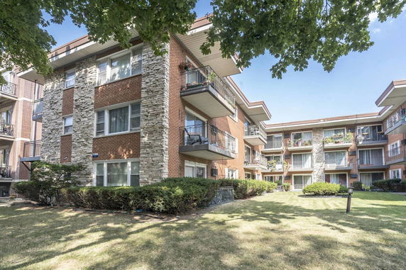 Front view of a multi-story apartment building with balconies.