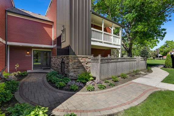 Front view of a house with red siding and a balcony.