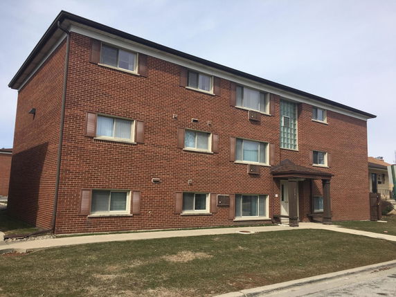 Front view of a three-story brick residential building.