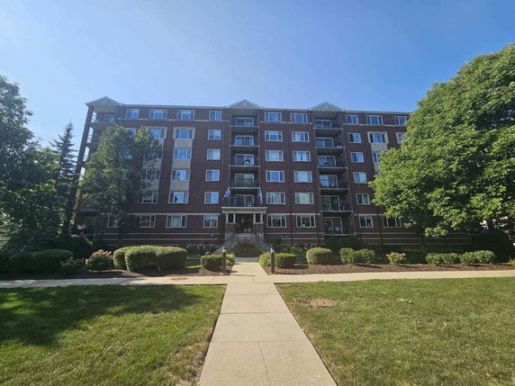 Front view of a multi-story brick apartment building.