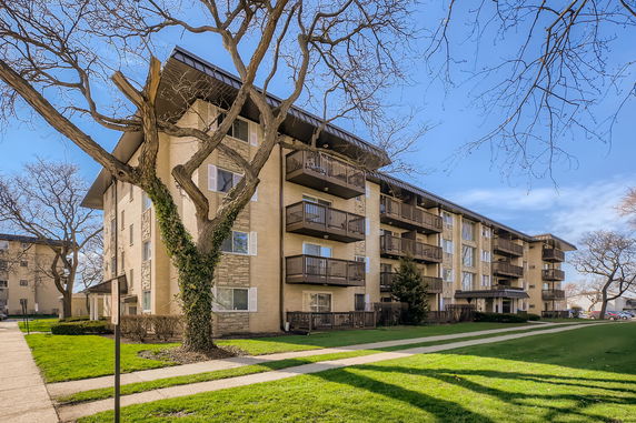 Front view of a multi-story apartment building with balconies.