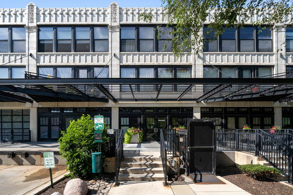 Front view of a multi-story building with large windows.