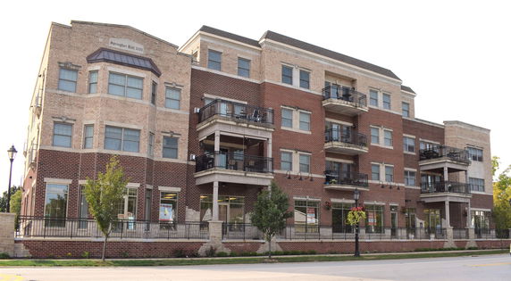 Front view of a multi-story building with brick facade and balconies.