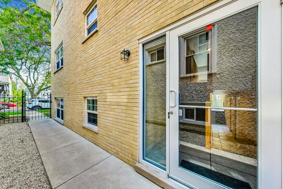 Side view of a brick building with glass door and windows.