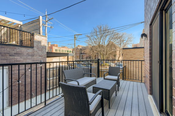 Rooftop area with outdoor seating and a view of surrounding structures.