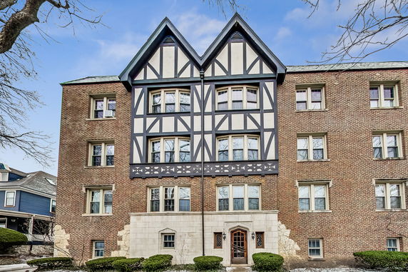 Front view of a multi-story building with Tudor architectural elements and brick facade.