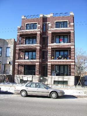 Front view of a multi-story brick building with balconies.