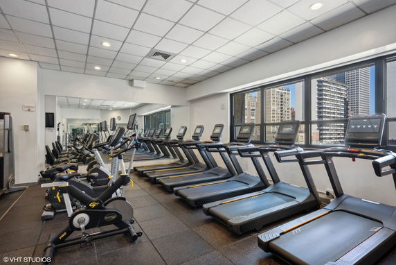 Interior view of a gym area with treadmills and exercise bikes.