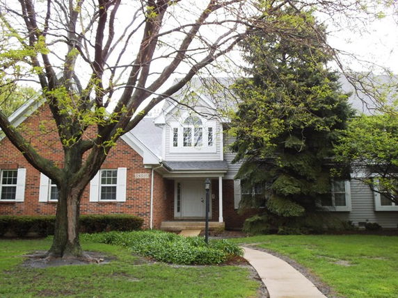Front view of a house with a brick and siding exterior and a prominent entryway.