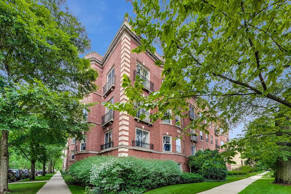 Front view of a multi-story brick building with a garden path.