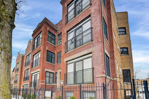 Front view of a multi-story brick building with balconies.