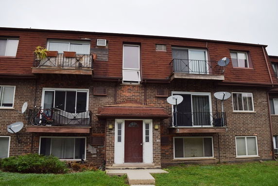Front view of a three-story apartment building with balconies.