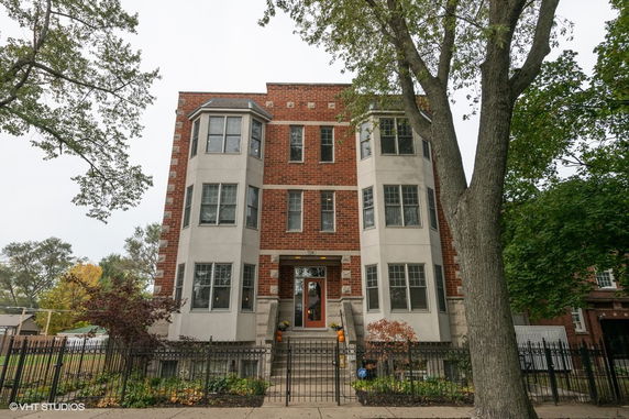 Front view of a multi-story brick building with large windows and steps leading to the entrance.
