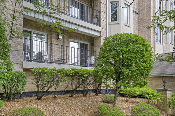 Front view of a residential building with brick exterior and balconies.