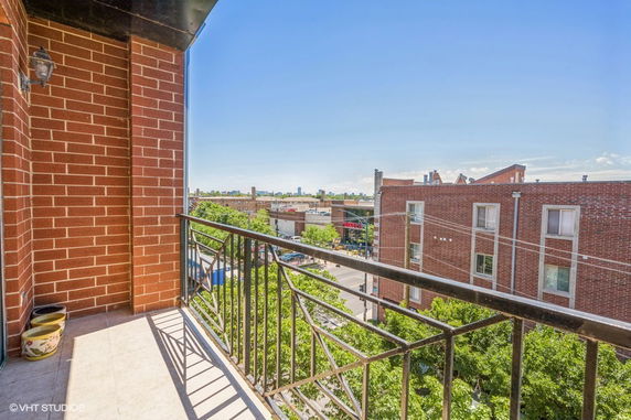 View from a balcony overlooking a cityscape with buildings in the background.